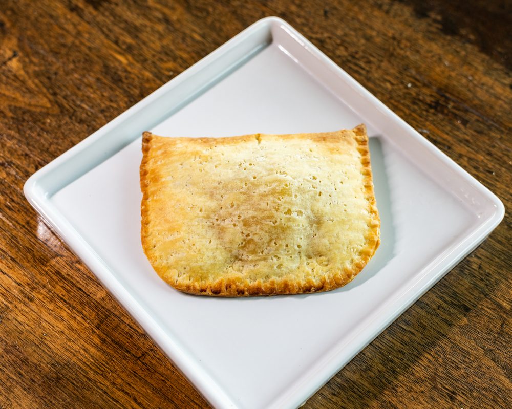 Golden Jamaican patties on a decorative plate