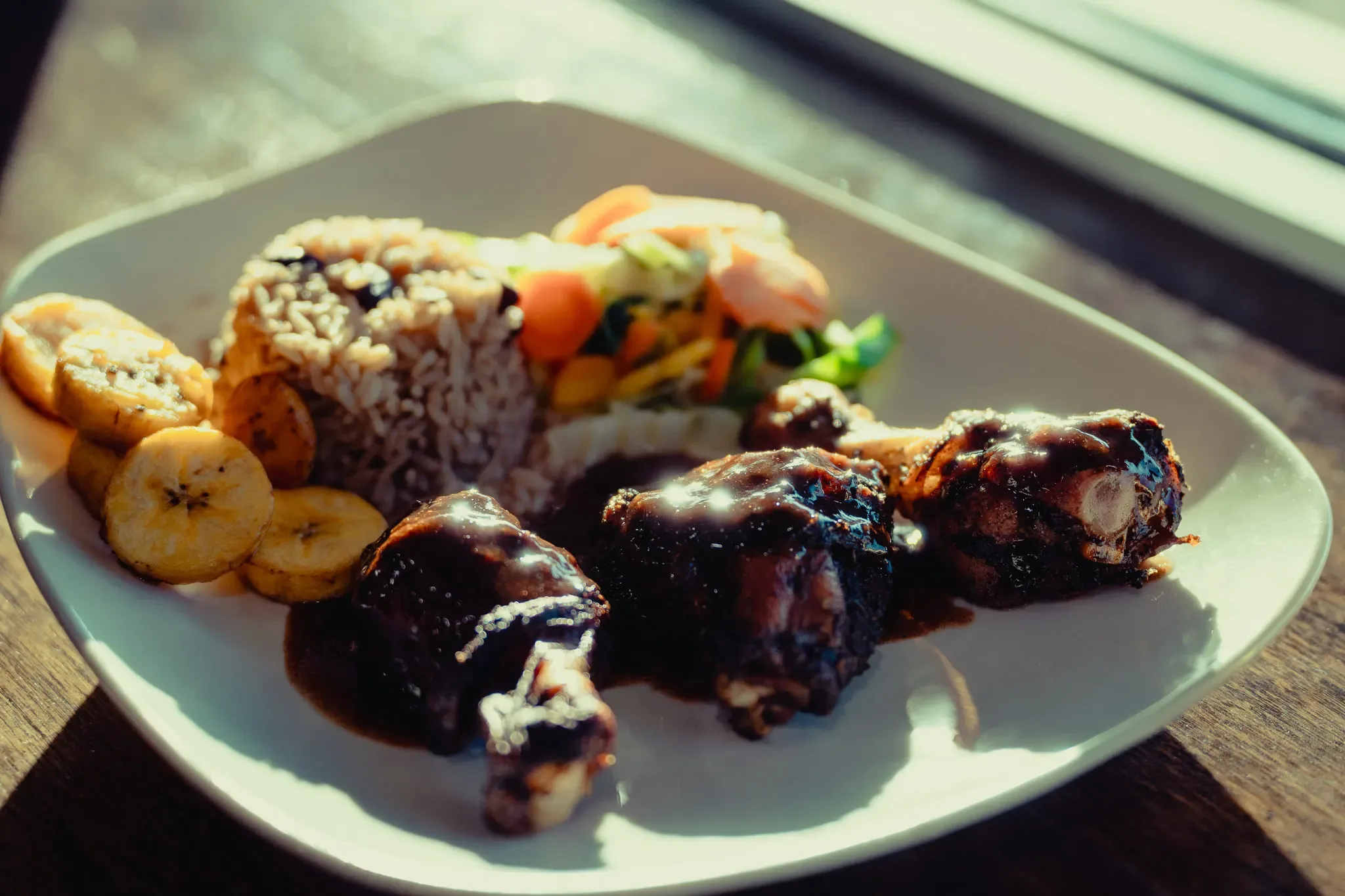 Jerk chicken plate with rice and peas, plantain and vegetables