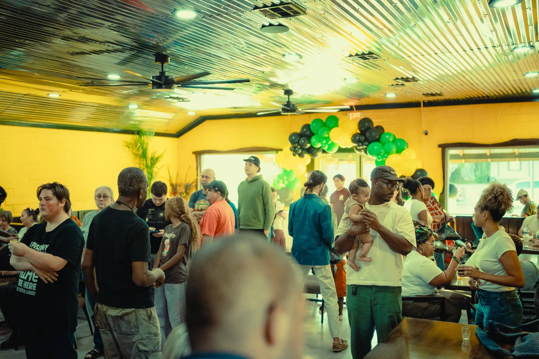 The new dining room packed with guests on opening night, with green and black balloons
