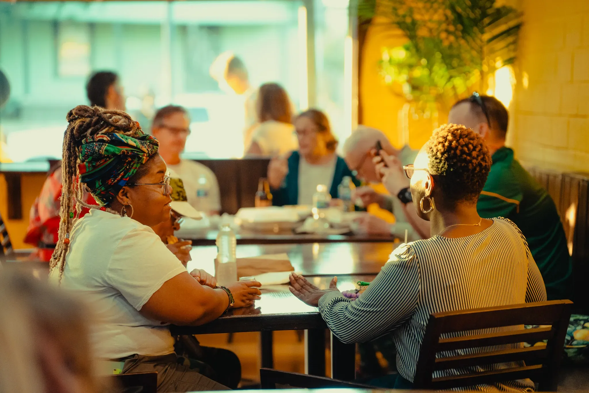 Guests sharing a meal at a table in warm evening light